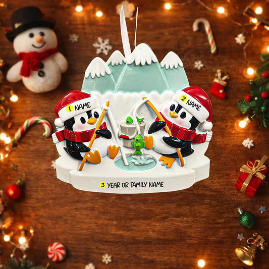 Personalized Christmas ornament with penguins ice skating on a wooden background with festive decorations.