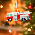 Load image into Gallery viewer, Fire truck ornament on a Christmas tree with blurred lights in the background
