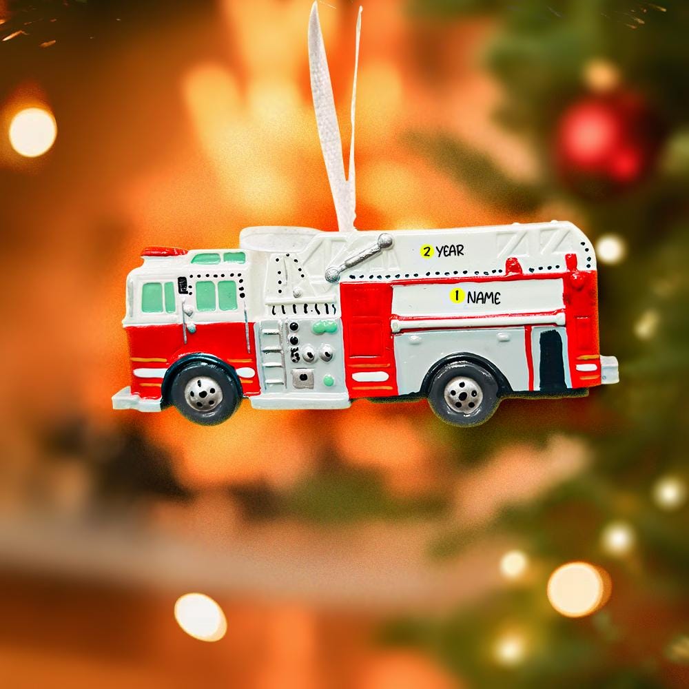 Fire truck ornament on a Christmas tree with blurred lights in the background