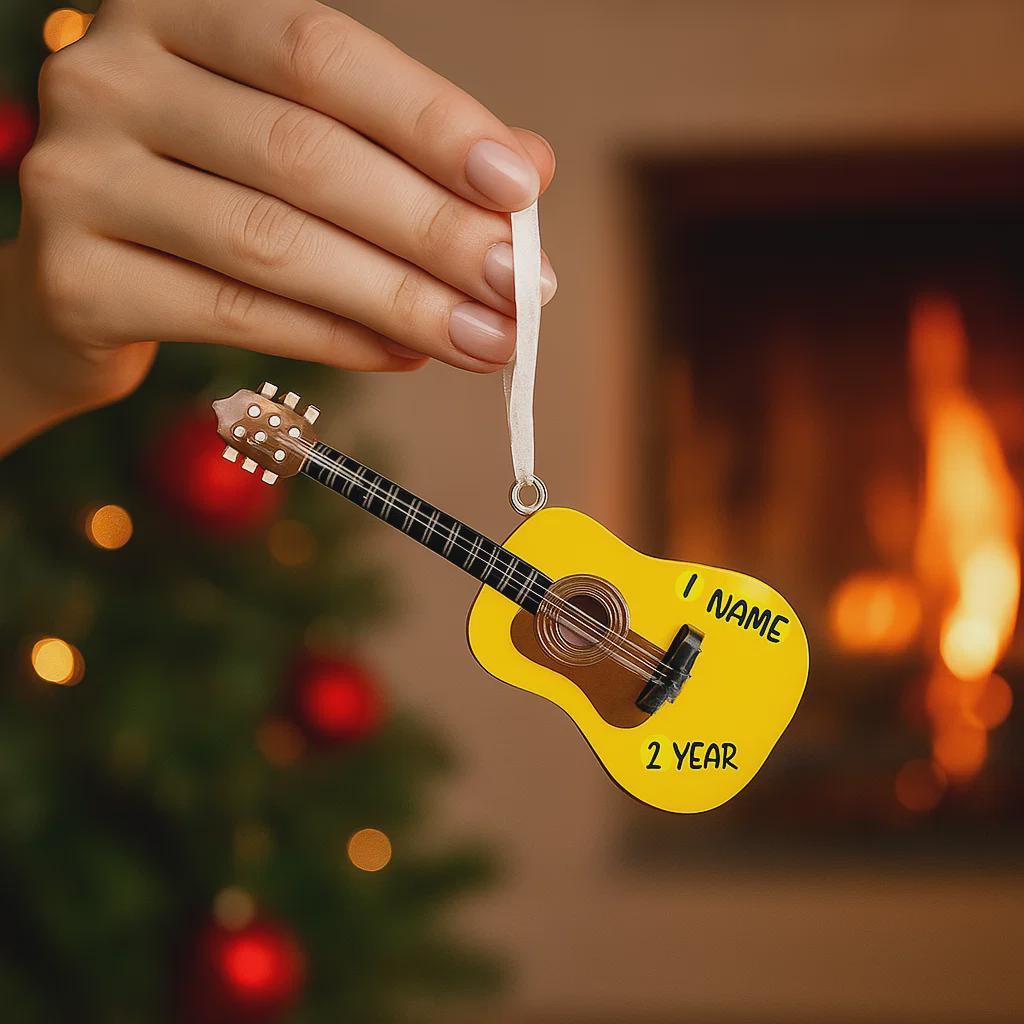 Personalized guitar ornament featuring a classic acoustic guitar design with detailed strings and wood texture. Custom name and year handwritten directly on the guitar body. High detail 3D resin ornament with white hanging ribbon. Perfect Christmas tree decoration for guitar players musicians music lovers and acoustic guitar fans. Warm musical theme ideal for holiday decor and meaningful personalized gifts.