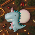 Load image into Gallery viewer, Unicorn-dinosaur toy on a wooden surface with Christmas decorations
