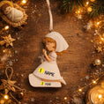 Load image into Gallery viewer, Decorative angel ornament with customizable text on a wooden background with Christmas decorations.
