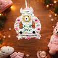 Load image into Gallery viewer, Personalized pink llama Christmas ornament featuring a cute white llama wrapped in colorful holiday lights, framed in a glittery wreath with pink accents. The top hat band can be customized with a name, while the bottom banner allows space for year or Baby’s 1st Christmas. Designed in soft pink and festive tones, this resin baby girl Christmas ornament makes a meaningful keepsake gift for celebrating a newborn’s first holiday season.


