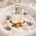 Load image into Gallery viewer, Personalized gender reveal Christmas ornament for baby girl featuring a pastel cake design with a cute elephant topper and its a gender message, soft pink and blue tones with layered cake details and glossy finish, styled as a sweet holiday keepsake for expecting parents, baby announcement and first Christmas memories, displayed on a warm wooden background with cozy Christmas lights, baby shoes and festive decor creating a joyful and heartwarming celebration scene
