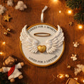 Load image into Gallery viewer, Decorative angel wing ornament with a heart on a wooden surface with Christmas decorations.
