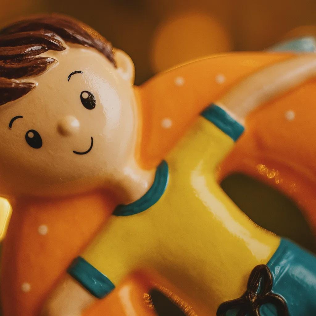Toy figure of a boy with a yellow shirt and blue shorts on a blurred background