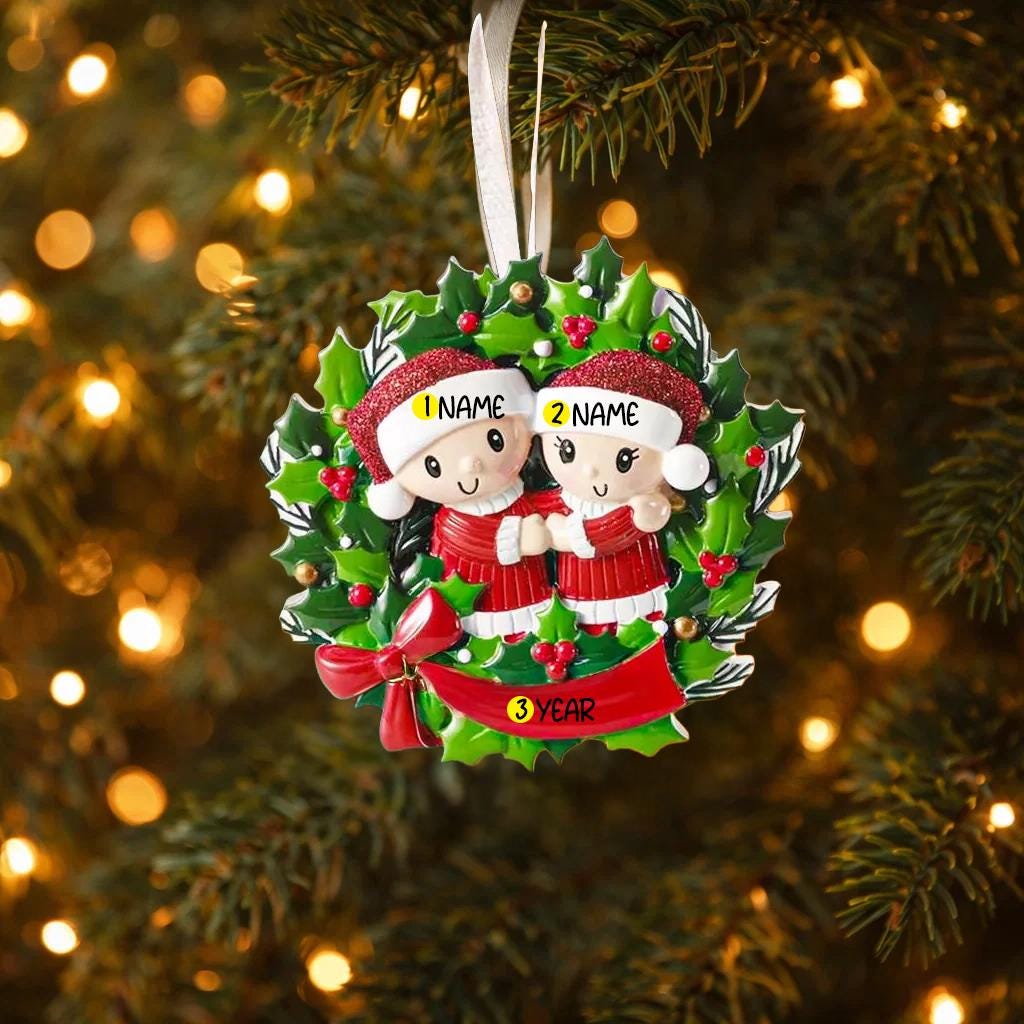 Personalized Christmas ornament with couple in a wreath on a decorated tree.