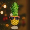 Load image into Gallery viewer, Pineapple ornament with sunglasses and a flower on a blurred Christmas tree background
