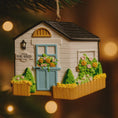 Load image into Gallery viewer, Decorative ornament of a small house with 'SHE SHED' sign on a blurred light background
