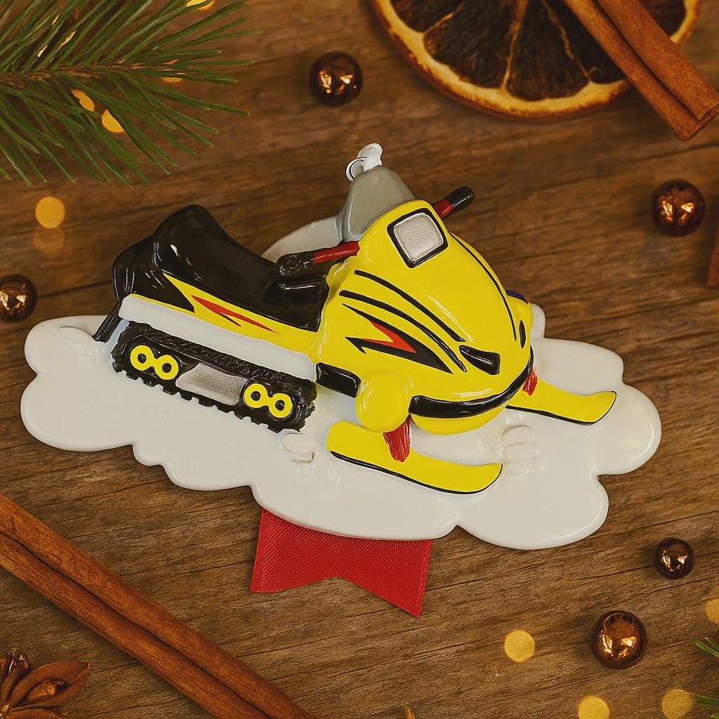 Decorative Christmas ornament with a snowmobile on a wooden surface with cinnamon sticks and orange slices.
