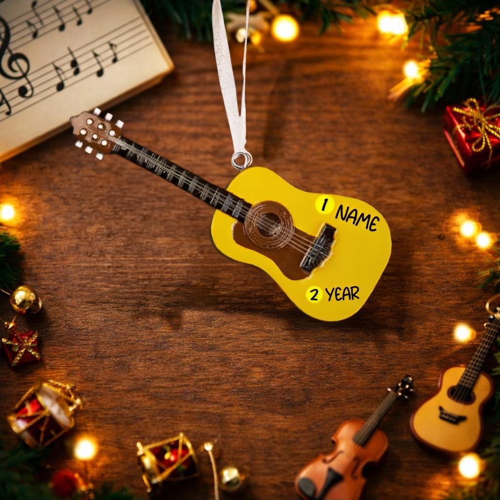 Personalized guitar ornament featuring a classic acoustic guitar design with detailed strings and wood texture. Custom name and year handwritten directly on the guitar body. High detail 3D resin ornament with white hanging ribbon. Perfect Christmas tree decoration for guitar players musicians music lovers and acoustic guitar fans. Warm musical theme ideal for holiday decor and meaningful personalized gifts.