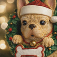 Load image into Gallery viewer, Decorative figurine of a dog wearing a Santa hat with a wreath and lights in the background
