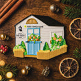 Load image into Gallery viewer, Decorative cookie shaped like a house with festive decorations on a wooden surface.
