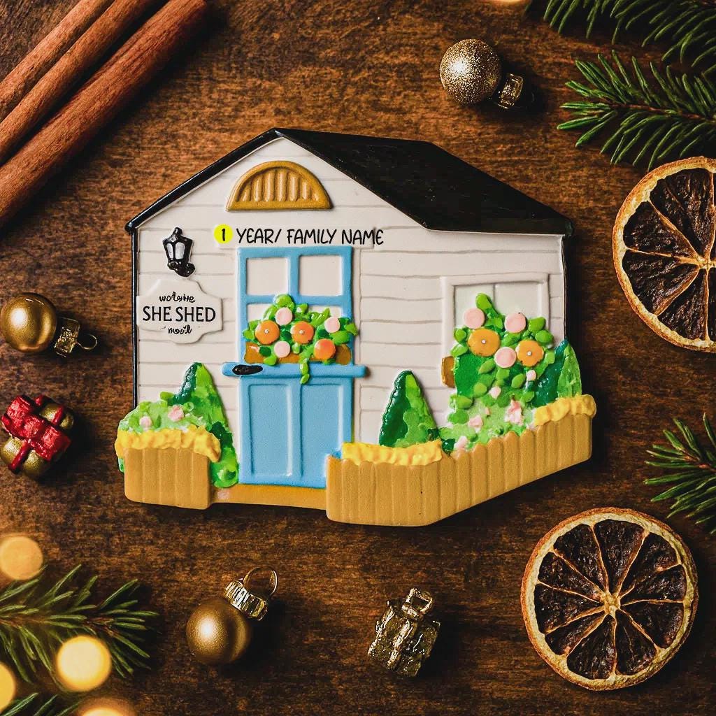 Decorative cookie shaped like a house with festive decorations on a wooden surface.