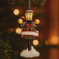 Load image into Gallery viewer, Decorative Christmas ornament resembling a street lamp with lights on a blurred Christmas tree background.
