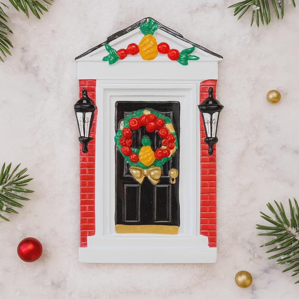 Decorative door ornament with a wreath, lanterns, and Christmas decorations on a light background.