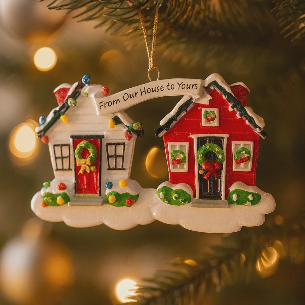Decorative Christmas ornament of two houses with a banner 'From Our House to Yours' on a blurred Christmas tree background.