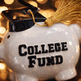 Load image into Gallery viewer, Piggy bank labeled 'College Fund' with a graduation cap and tassel on a blurred background
