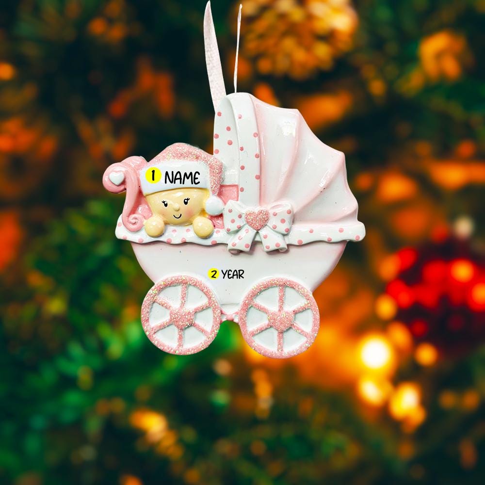 Personalized baby girl Christmas ornament featuring a soft pink stroller with glitter details and a smiling baby wearing a pink nightcap. Custom name appears on the top and year on the bottom, making it a perfect Baby’s First Christmas keepsake. This pink resin holiday ornament is ideal for newborn girls, baby shower gifts, and celebrating a special first Christmas memory.
