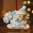 Load image into Gallery viewer, Personalized Baby Boy First Christmas Ornament featuring an adorable baby popping out of a blue gift box with a matching hat and pacifier. The name is displayed on the hat while the year is placed on the ribbon detail, with Baby’s 1st Christmas written along the base. Soft blue and white tones, raised 3D elements, and sweet holiday details make this a charming keepsake. Perfect for newborn boys, baby showers, and celebrating a baby’s very first Christmas season.
