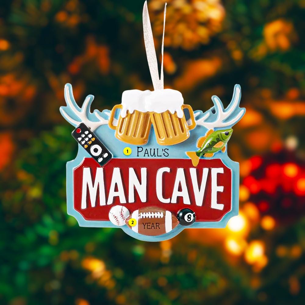 Man cave themed personalized ornament featuring a bold red Man Cave sign design with raised 3D details including beer mugs antlers sports icons and hobby elements. The ornament allows name personalization on the top area and year personalization at the bottom making it a fun and meaningful keepsake. Designed with a flat back for easy hanging this ornament is perfect for man cave decor Christmas trees or gift displays. Ideal for dads husbands boyfriends and anyone who loves their personal space traditions an