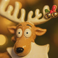 Load image into Gallery viewer, Close-up of a ceramic reindeer figurine with gold bells on a blurred background
