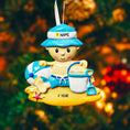 Load image into Gallery viewer, Personalized Beach Baby Christmas Ornament featuring a cheerful toddler sitting on the sand with a beach hat, float, bucket, and shovel. This detailed 3D front design includes raised elements, bright summer colors, and textured sand base for added depth. The name is placed on the hat and the year on the sandy base. A perfect keepsake for baby’s first beach trip or summer memory, ideal for Christmas tree decor or a thoughtful holiday gift for new parents.
