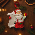 Load image into Gallery viewer, Decorative Christmas ornament of Santa Claus holding a 'Nice List' sign on a wooden background.
