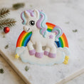 Load image into Gallery viewer, Unicorn cookie with rainbow on a marble surface

