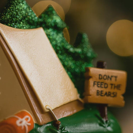 Toy bear in a camping scene with a 'Don't Feed the Bears!' sign