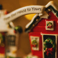 Load image into Gallery viewer, Decorative Christmas house ornament with a wreath and text on a blurred background
