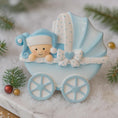Load image into Gallery viewer, Personalized baby boy Christmas ornament featuring a light blue stroller with glitter details and a smiling baby wearing a blue nightcap. Custom name appears on the top and year on the bottom, making it a perfect Baby’s First Christmas keepsake. This blue resin holiday ornament is ideal for newborn boys, baby shower gifts, and celebrating a special first Christmas memory.
