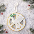 Load image into Gallery viewer, Decorative Christmas ornament with a dove and peace symbol on a snowy background.
