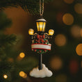 Load image into Gallery viewer, Decorative Christmas ornament resembling a street lamp with lights on a blurred festive background.
