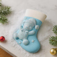 Load image into Gallery viewer, A glossy resin baby boy stocking ornament features a soft pastel blue Christmas stocking shape with a raised glitter style baby figure on the front, white cuff detail, small star accents, and smooth painted surfaces, surrounded by warm holiday lights and nursery themed props, handwritten personalization showing one baby name on the top cuff and the year written near the bottom of the stocking, designed as a mostly 2D ornament with raised 3D details on the front only.
