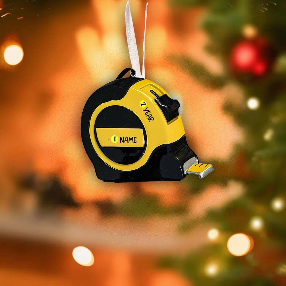 Yellow tape measure ornament on a Christmas tree with blurred lights in the background