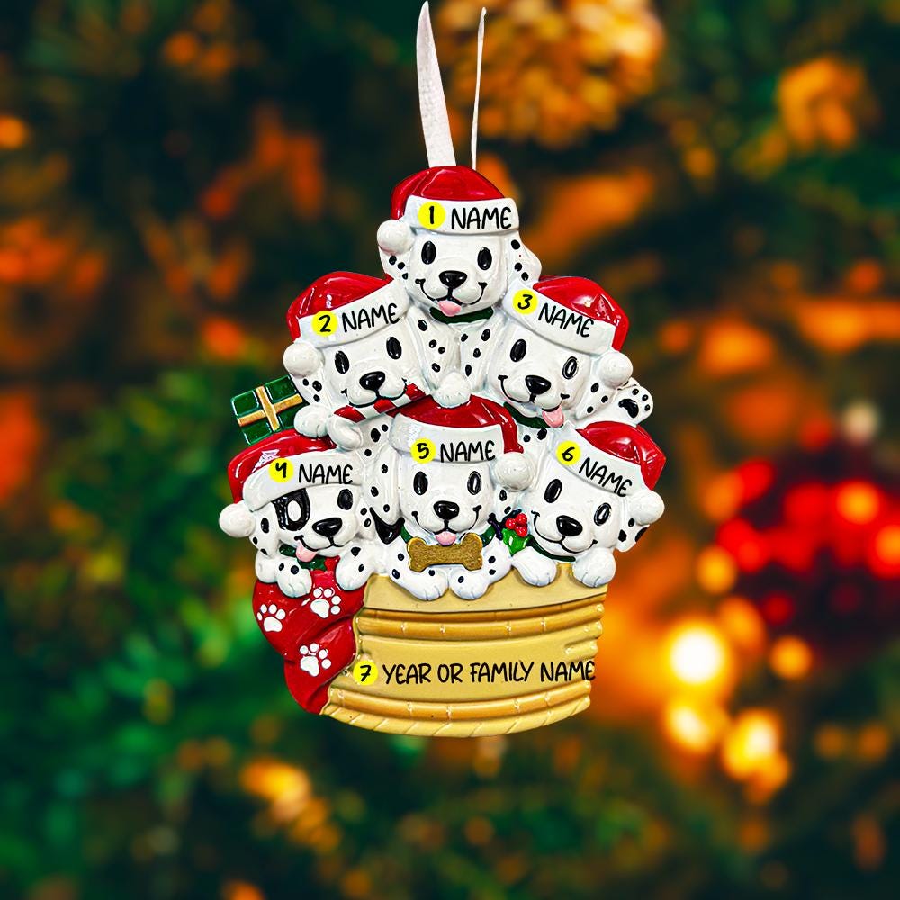 Personalized Christmas ornament with six dalmatians in a basket, each labeled with a name, on a blurred Christmas tree background.