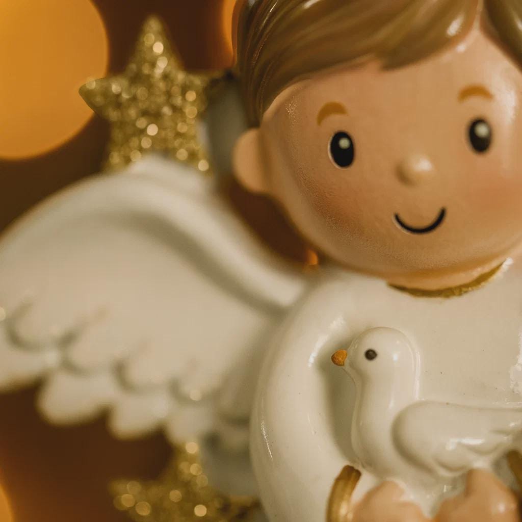 Decorative angel figurine holding a dove with a star in the background