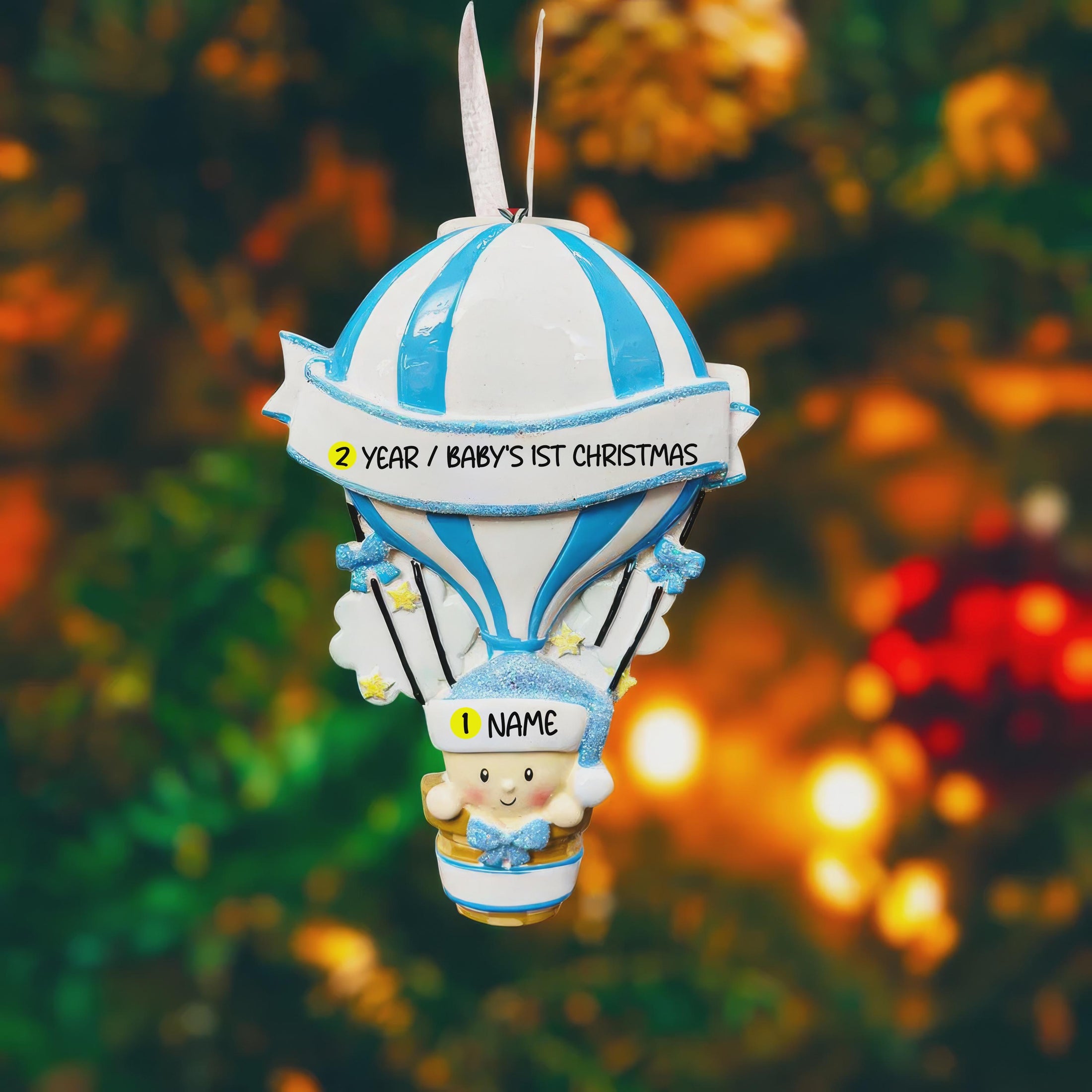 Personalized Baby Boy First Christmas Ornament designed as a charming 3D hot air balloon with a sweet baby in the basket below. The name is featured on the lower section and the year or Baby’s First Christmas message appears on the banner across the balloon. Soft blue and white tones, glitter accents, and raised dimensional details create a playful keepsake. Perfect for newborn boys, baby shower gifts, and celebrating a baby’s first holiday season.