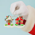 Load image into Gallery viewer, Christmas ornament shaped like a house with 'From Our House to Yours' text, held by a gloved hand.
