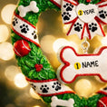 Load image into Gallery viewer, Decorative wreath ornament with customizable name tag on a blurred light background
