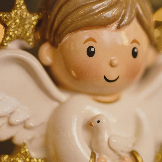 Decorative angel figurine with a dove on a gold star background