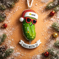 Load image into Gallery viewer, Christmas pickle ornament with sunglasses and Santa hat on a decorative background
