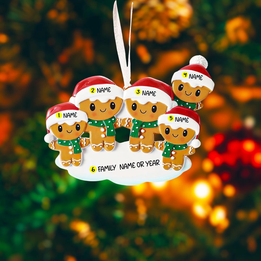Gingerbread family ornament with customizable names against a blurred Christmas tree background