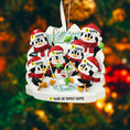 Load image into Gallery viewer, Personalized Christmas ornament with penguins on a blurred Christmas tree background

