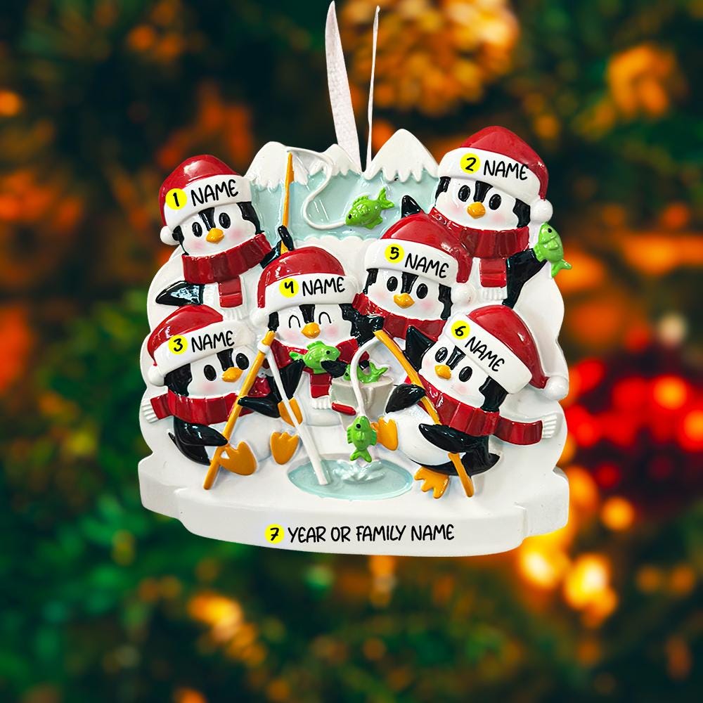 Personalized Christmas ornament with penguins on a blurred Christmas tree background