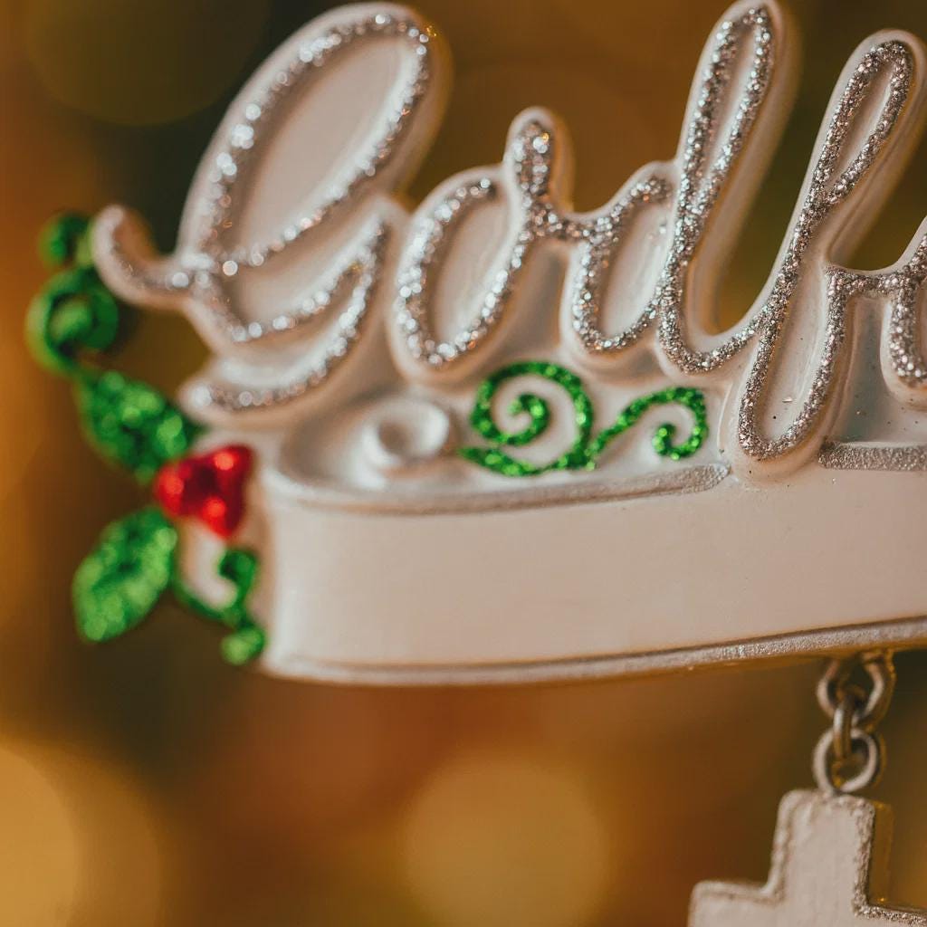 Decorative letter 'G' with gold glitter, green leaves, and red berry on a blurred background