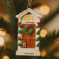 Load image into Gallery viewer, Decorative Christmas door ornament with wreaths and text on a blurred Christmas tree background.
