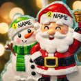 Load image into Gallery viewer, Personalized Santa and snowman ornament featuring a classic Christmas design with Santa holding a bell and a smiling snowman standing beside him. The ornament includes custom name and year personalization on the figures and base. Finished with a smooth glossy surface and detailed 3D front, it is designed for easy hanging on a Christmas tree. Perfect for festive holiday decor, family keepsakes, and seasonal gift giving.
