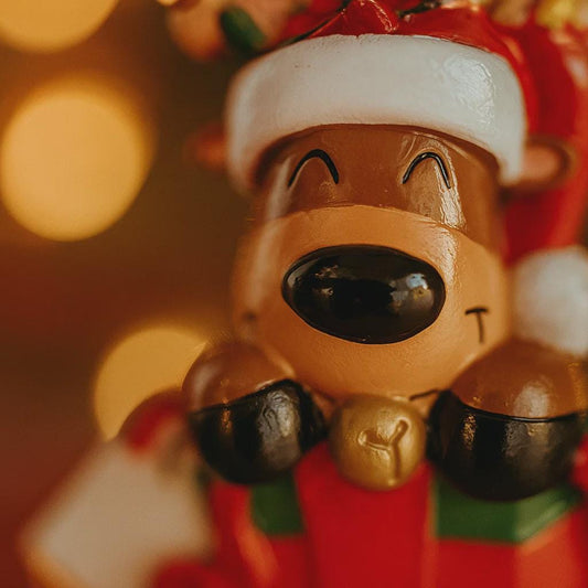 Close-up of a reindeer figurine with a Santa hat against a blurred light background